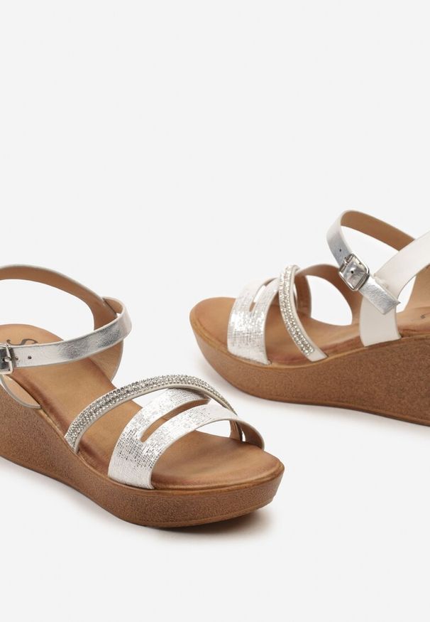 Renee - Srebrne Sandały na Koturnie Zapinane na Sprzączkę z Cyrkoniami Wykończone Metaliczną Nitką Herasta. Nosek buta: otwarty. Zapięcie: sprzączka. Kolor: srebrny. Sezon: lato. Obcas: na koturnie. Styl: wakacyjny, elegancki
