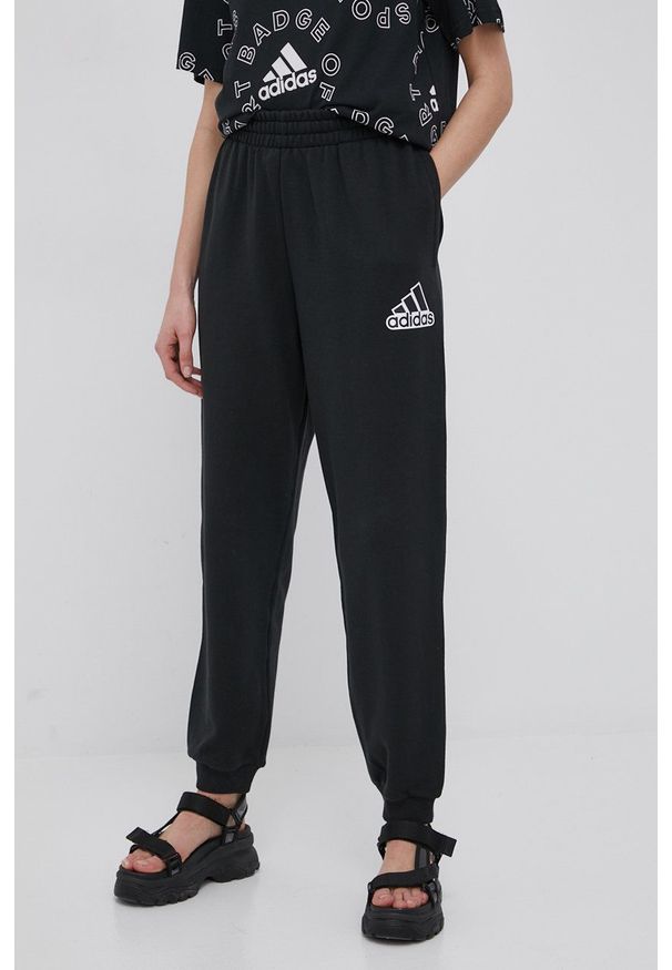Adidas - adidas spodnie bawełniane HC9176 damskie kolor czarny z nadrukiem. Stan: podwyższony. Kolor: czarny. Materiał: bawełna. Wzór: nadruk