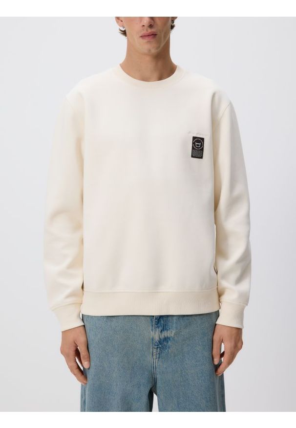 Reserved - Bluza z naszywką - złamana biel. Materiał: bawełna, dzianina. Wzór: aplikacja