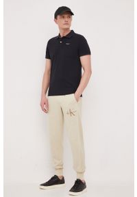 Calvin Klein Jeans spodnie dresowe bawełniane kolor beżowy gładkie. Kolor: beżowy. Materiał: bawełna, dresówka. Wzór: gładki