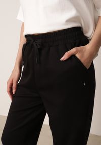 Born2be - Czarne Spodnie Dresowe Joggery z Wysokim Stanem i Ściągaczami przy Kostkach Janlea. Okazja: do domu, na co dzień, na spacer. Stan: podwyższony. Kolor: czarny. Materiał: dresówka. Długość: krótkie. Styl: sportowy, klasyczny, casual #4