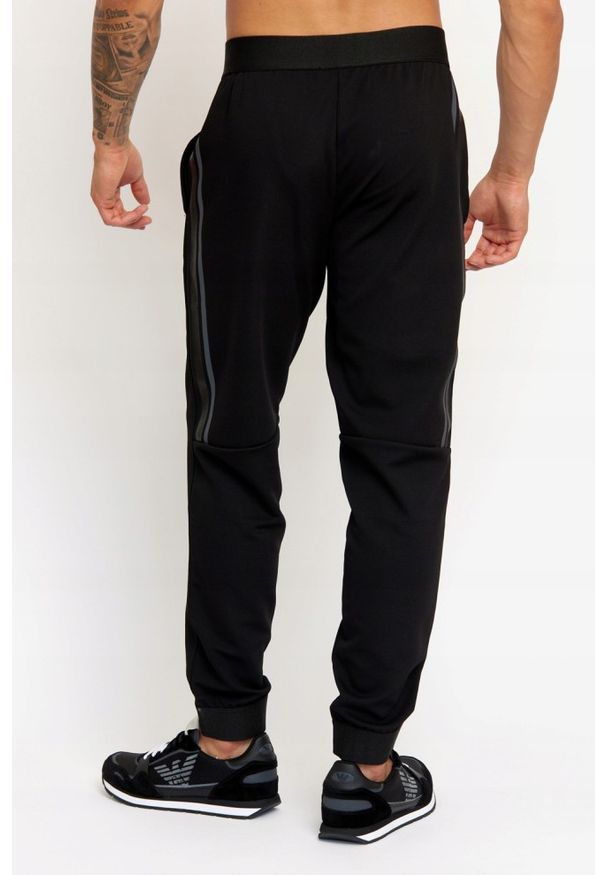 EA7 Emporio Armani - EA7 Spodnie dresowe z lampasami. Kolor: czarny. Materiał: poliester. Wzór: aplikacja