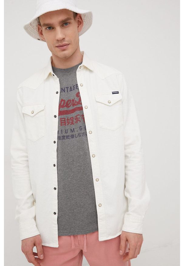 Superdry koszula bawełniana męska kolor beżowy regular z kołnierzykiem klasycznym. Typ kołnierza: kołnierzyk klasyczny. Kolor: beżowy. Materiał: bawełna. Długość rękawa: długi rękaw. Długość: długie. Styl: klasyczny