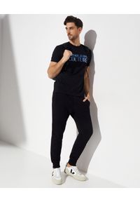 Versace Jeans Couture - VERSACE JEANS COUTURE - Koszulka z holograficznym logo. Kolor: czarny. Materiał: bawełna