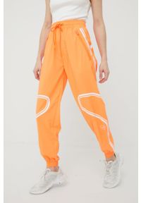 Adidas by Stella McCartney - adidas by Stella McCartney spodnie treningowe Truepace damskie kolor pomarańczowy z nadrukiem. Kolor: pomarańczowy. Materiał: materiał. Wzór: nadruk