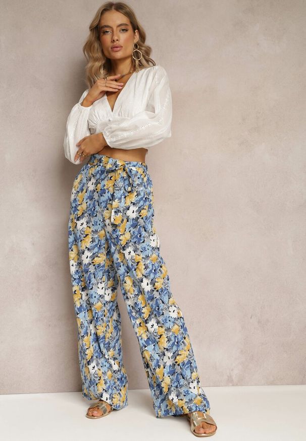 Renee - Niebieskie Długie Spodnie z Szerokimi Nogawkami oraz Kieszeniami i Materiałowym Paskiem Omina. Okazja: na plażę. Kolor: niebieski. Materiał: materiał. Długość: długie. Wzór: nadruk, kwiaty