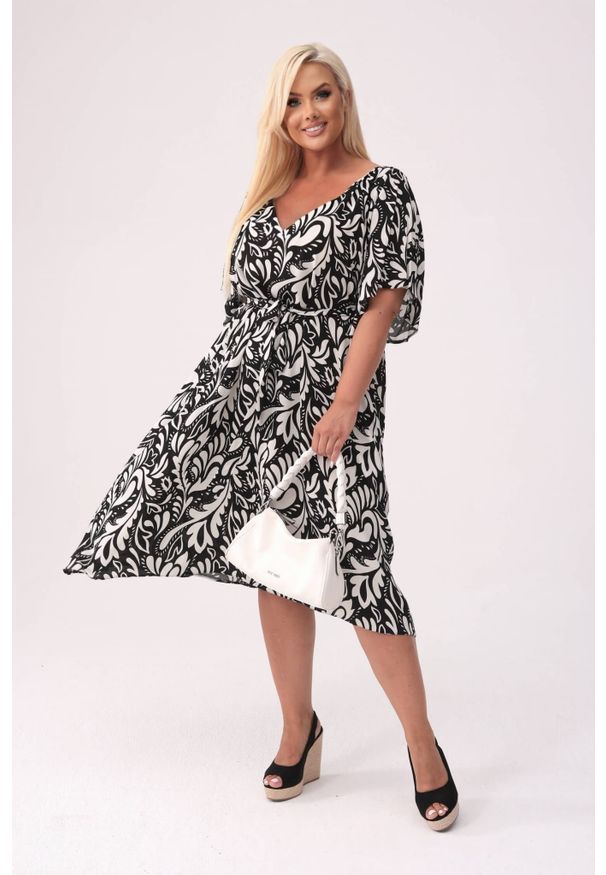 Moda Size Plus Iwanek - Sukienka Arie w biało-czarny print XXL OVERSIZE. Okazja: na co dzień. Typ kołnierza: dekolt w kształcie V. Kolor: biały, czarny, wielokolorowy. Materiał: wiskoza, tkanina, materiał. Wzór: nadruk. Typ sukienki: oversize. Styl: casual, elegancki. Długość: midi