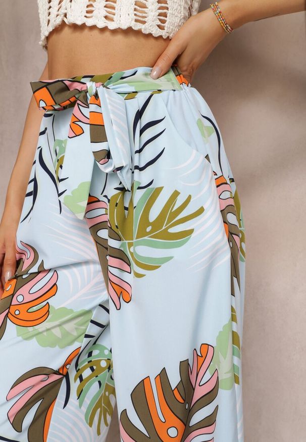 Renee - Jasnoniebieskie Spodnie Szerokie Sofadia. Okazja: na co dzień. Stan: podwyższony. Kolor: niebieski. Materiał: materiał. Wzór: nadruk, aplikacja, paski. Styl: casual