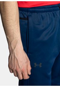 Spodnie dresowe męskie granatowe Under Armour Fleece. Kolor: niebieski. Materiał: dresówka. Sport: fitness