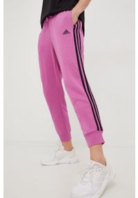 Adidas - adidas spodnie dresowe damskie kolor fioletowy z aplikacją. Kolor: fioletowy. Materiał: dresówka. Wzór: aplikacja #1