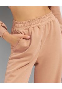 THECADESS - Beżowe spodnie dresowe Lorin. Kolor: beżowy. Materiał: dresówka