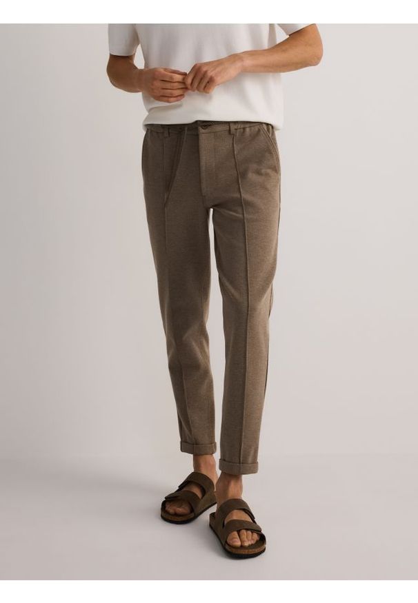 Reserved - Spodnie chino slim - beżowy. Kolor: beżowy. Materiał: dzianina, bawełna