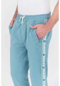 Guess - GUESS Turkusowe dresowe spodnie New Arlo. Kolor: niebieski. Materiał: dresówka #3