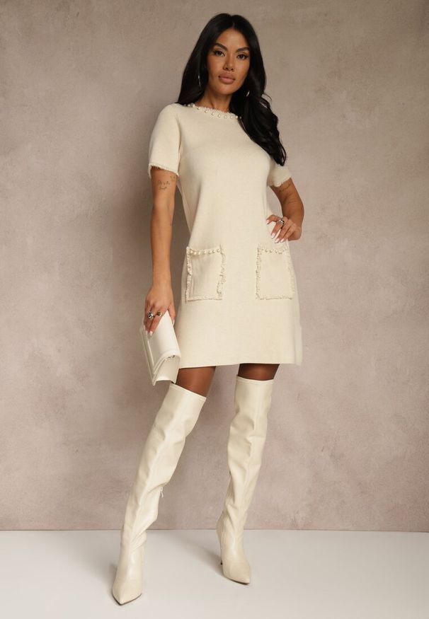 Renee - Jasnobeżowa Sweterkowa Sukienka Trapezowa z Perełkami przy Dekolcie i Kieszeniach Fenatusa. Okazja: na co dzień. Kolor: beżowy. Materiał: jeans. Typ sukienki: trapezowe. Styl: casual