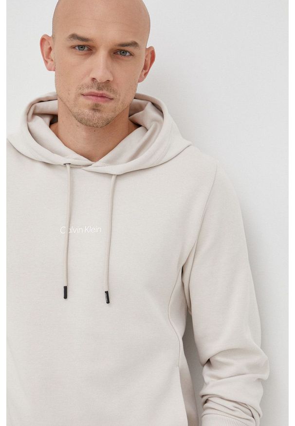 Calvin Klein bluza męska kolor beżowy z kapturem gładka. Typ kołnierza: kaptur. Kolor: beżowy. Wzór: gładki