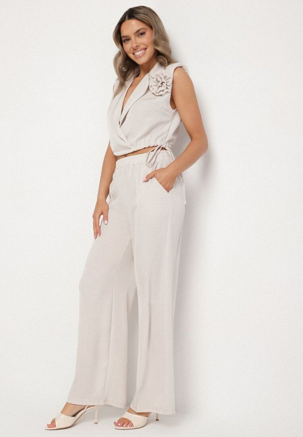 Born2be - Beżowy Komplet Kopertowa Bluzka z Kwiatową Broszką i Szerokie Spodnie Reavilia. Kolor: beżowy. Wzór: kwiaty