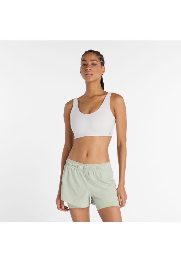 Biustonosz New Balance WB51052GYM – biały. Kolor: biały. Materiał: skóra, poliester, lycra, materiał, tkanina. Wzór: gładki. Sport: fitness