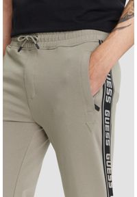 Guess - GUESS Zielone męskie spodnie dresowe z lampasami New Arlo, Rozmiar S. Kolor: zielony. Materiał: dresówka #4