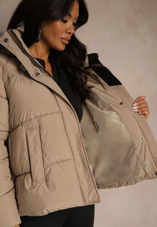 Renee - Ciemnobeżowa Pikowana Kurtka o Fasonie Oversize z Kapturem Galadea. Okazja: na co dzień. Typ kołnierza: kaptur. Kolor: beżowy. Materiał: jeans, dzianina, poliester. Wzór: aplikacja. Sezon: zima. Styl: casual