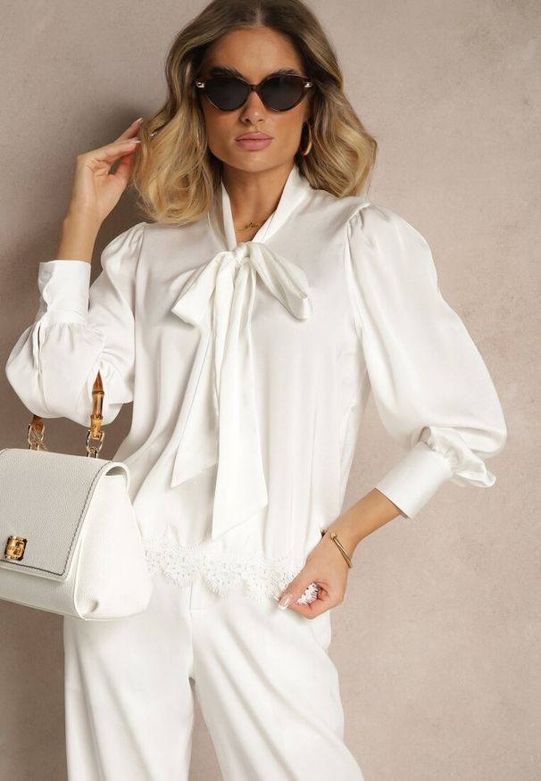 Renee - Biała Bluzka Wiązana Przy Dekolcie z Ażurową Koronką na Dole Haliritia. Okazja: na co dzień. Kolor: biały. Materiał: koronka. Długość rękawa: długi rękaw. Długość: długie. Wzór: ażurowy, koronka. Styl: casual, elegancki