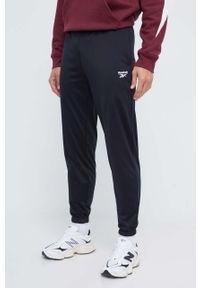 Reebok spodnie dresowe kolor czarny gładkie. Kolor: czarny. Materiał: dresówka. Wzór: gładki #1