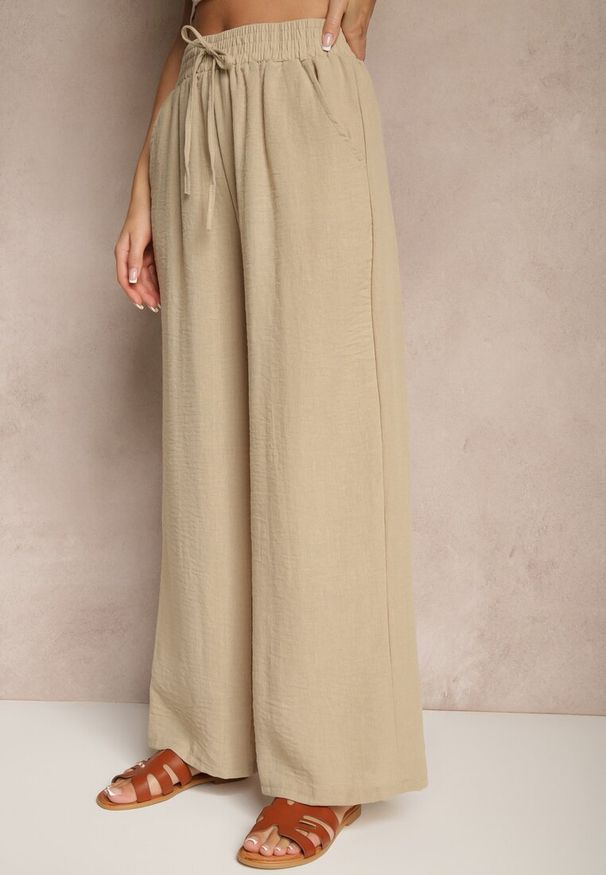 Renee - Beżowe Szerokie Spodnie Palazzo High Waist z Ozdobnym Wiązaniem Arandiel. Okazja: na co dzień. Stan: podwyższony. Kolor: beżowy. Materiał: jedwab. Styl: street, wizytowy, casual