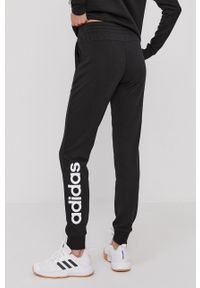 Adidas - adidas Spodnie damskie kolor czarny z nadrukiem. Kolor: czarny. Materiał: poliester. Wzór: nadruk