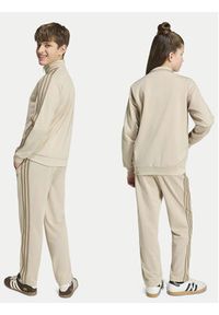 Adidas - adidas Spodnie dresowe Firebird HZ6652 Beżowy jasny Regular Fit. Kolor: beżowy. Materiał: syntetyk #7