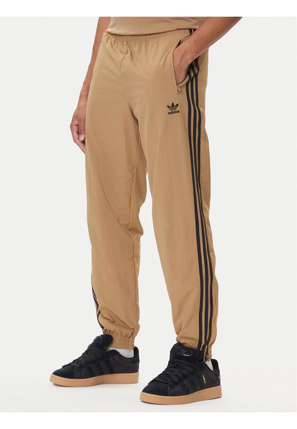 Adidas - adidas Spodnie dresowe adicolor Woven Firebird JY1339 Beżowy Regular Fit. Kolor: beżowy. Materiał: syntetyk