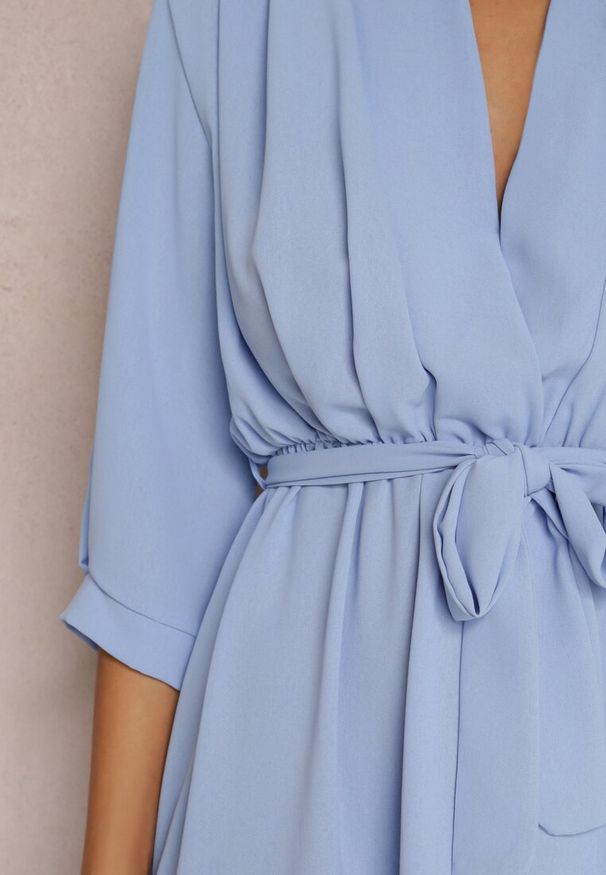 Renee - Jasnoniebieska Sukienka Canopis. Typ kołnierza: dekolt kopertowy. Kolor: niebieski. Materiał: materiał, tkanina. Typ sukienki: kopertowe. Styl: elegancki. Długość: midi