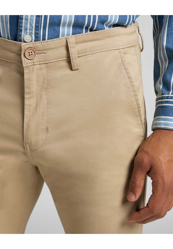 Lee - LEE SLIM CHINO MĘSKIE SPODNIE MATERIAŁOWE SERVICE SAND L768LA10 112121061. Materiał: materiał