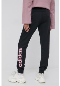 Adidas - adidas spodnie damskie kolor czarny z nadrukiem. Kolor: czarny. Materiał: materiał. Wzór: nadruk