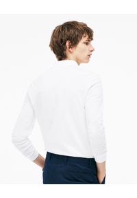 Lacoste - LACOSTE - Biały t-shirt polo z długim rękawem Regular Fit. Okazja: na spotkanie biznesowe, na co dzień, do pracy. Typ kołnierza: polo. Kolor: biały. Materiał: jeans, dresówka, tkanina. Długość rękawa: długi rękaw. Długość: długie. Wzór: haft. Styl: biznesowy, klasyczny, casual, sportowy #3