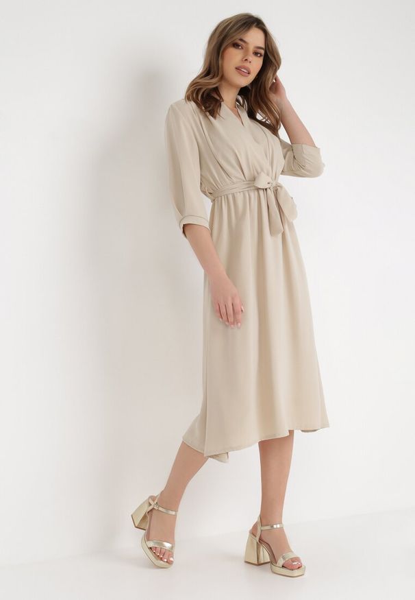 Born2be - Beżowa Sukienka Rheniolea. Typ kołnierza: dekolt kopertowy. Kolor: beżowy. Typ sukienki: kopertowe. Styl: elegancki. Długość: midi