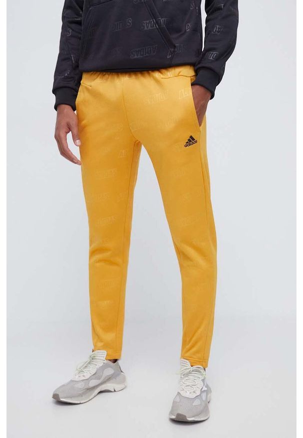 Adidas - adidas spodnie dresowe kolor żółty wzorzyste. Kolor: żółty. Materiał: dresówka