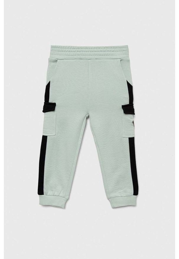 Guess spodnie dresowe bawełniane dziecięce kolor turkusowy wzorzyste. Stan: podwyższony. Kolor: turkusowy. Materiał: bawełna, dresówka