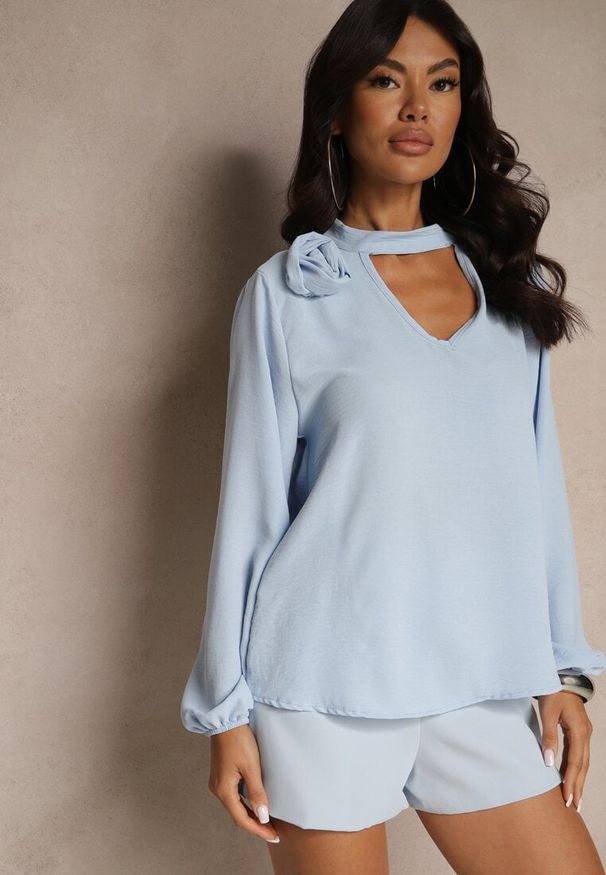 Renee - Jasnoniebieska Bluzka z Ozdobnym Kwiatem Tolna. Kolor: niebieski. Wzór: kwiaty