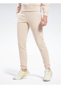 Reebok Spodnie dresowe Fleece IC3502 Beżowy Slim Fit. Kolor: beżowy. Materiał: bawełna