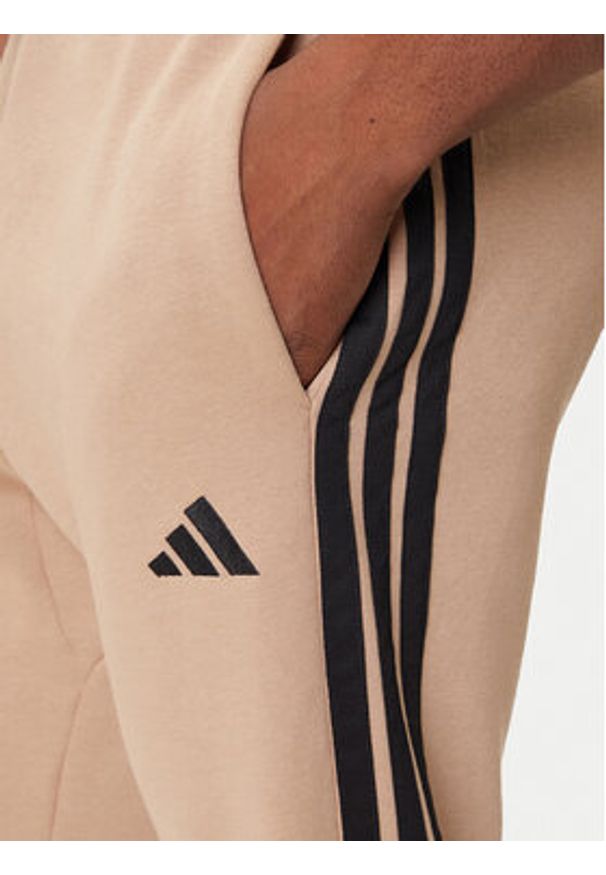 Adidas - adidas Spodnie dresowe Essentials 3-Stripes JX0712 Beżowy Regular Fit. Kolor: beżowy. Materiał: syntetyk