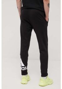 Adidas - adidas spodnie męskie kolor czarny z nadrukiem. Kolor: czarny. Materiał: poliester, bawełna. Wzór: nadruk
