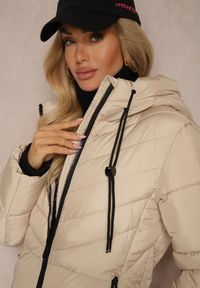 Renee - Ciemnobeżowa Długa Kurtka z Pikowanymi Przeszyciami Dwustronnym Suwakiem i Kapturem Fezilda. Okazja: na co dzień, na spacer. Kolor: beżowy. Materiał: jeans. Długość rękawa: długi rękaw. Długość: długie. Styl: klasyczny, elegancki, casual