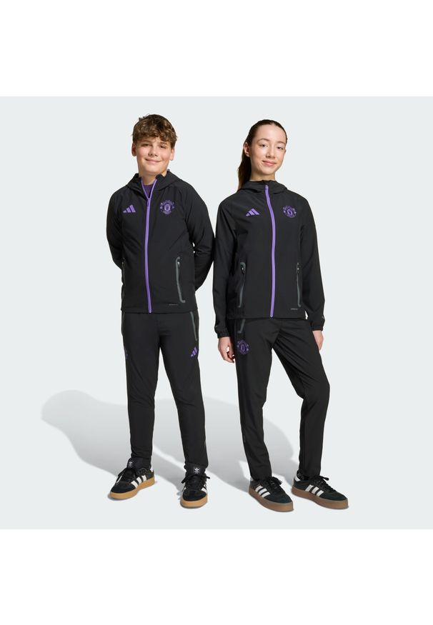 Adidas - Spodnie Manchester United Tiro 25 Competition Vis Tech Travel Kids. Kolor: fioletowy, wielokolorowy, czarny. Sport: piłka nożna