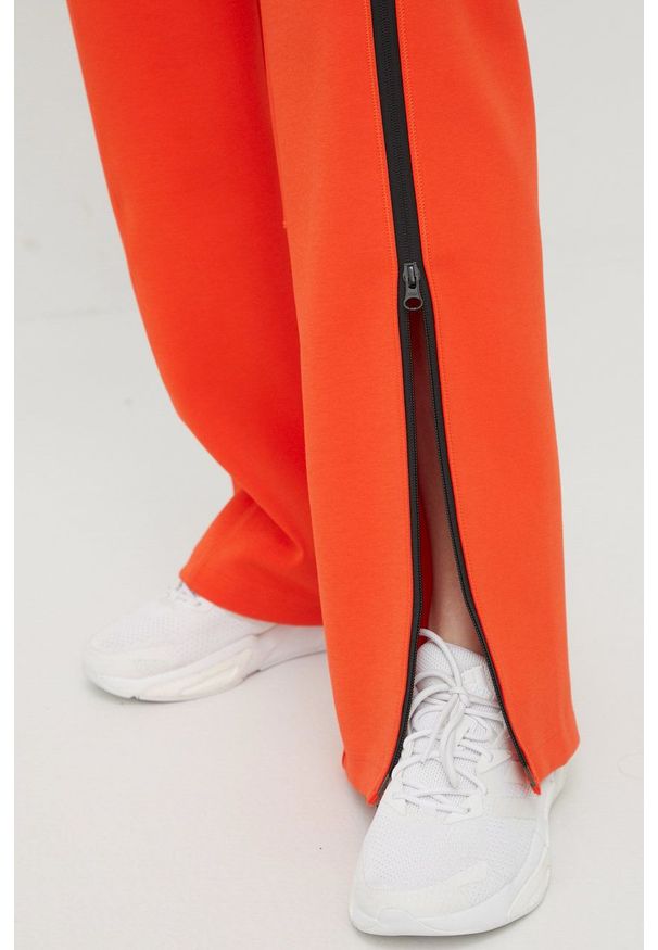 Adidas by Stella McCartney - adidas by Stella McCartney spodnie dresowe damskie kolor pomarańczowy z nadrukiem. Kolor: pomarańczowy. Materiał: dresówka. Wzór: nadruk