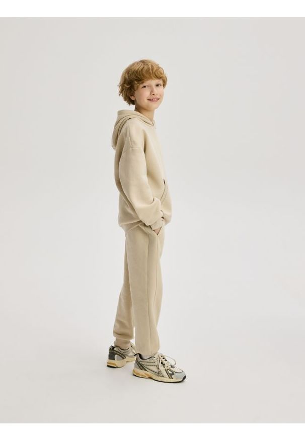 Reserved - Bawełniane joggery z meszkiem - beżowy. Kolor: beżowy. Materiał: bawełna