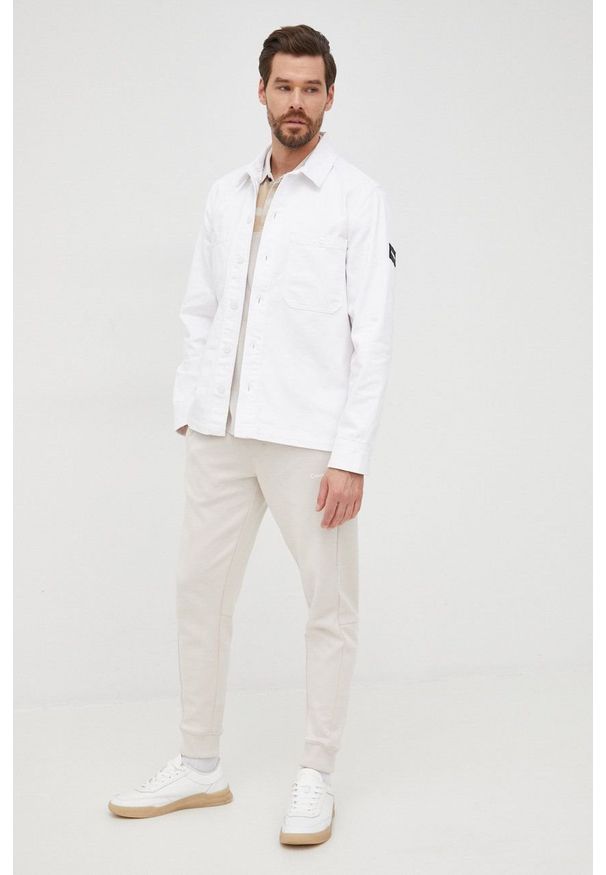 Calvin Klein spodnie męskie kolor beżowy gładkie. Kolor: beżowy. Wzór: gładki