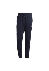 Adidas - Spodnie dresowe męskie adidas Essentials Fleece Regular Tapered. Kolor: czarny, biały, wielokolorowy. Materiał: dresówka