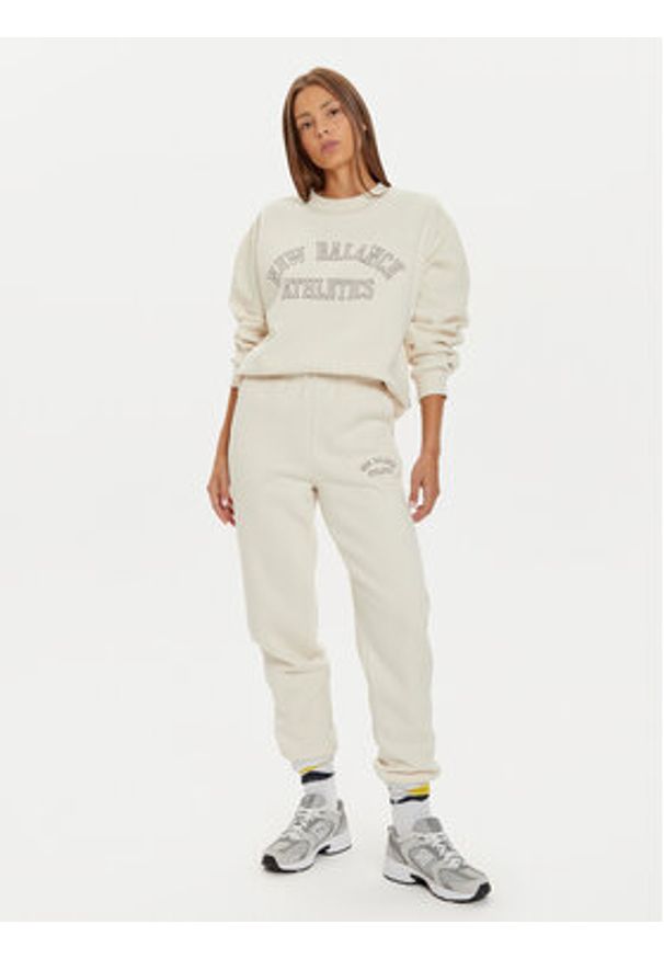 New Balance Spodnie dresowe WP43500 Beżowy Relaxed Fit. Kolor: beżowy. Materiał: syntetyk, bawełna