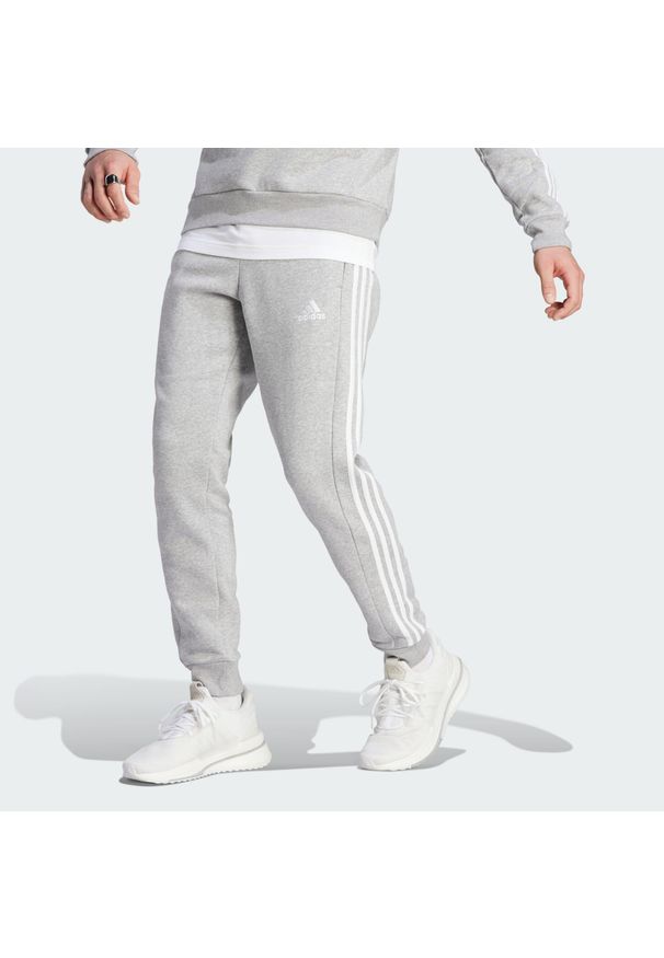 Adidas - Spodnie Essentials Fleece 3-Stripes Tapered Cuff. Kolor: szary. Materiał: polar, materiał