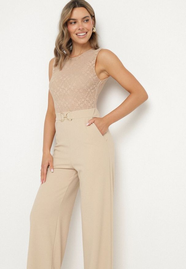 Born2be - Jasnobeżowy Kombinezon bez Rękawów z Metaliczną Ozdobą i Prostymi Nogawkami Karivalle. Okazja: na co dzień. Kolor: beżowy. Długość rękawa: bez rękawów. Wzór: aplikacja. Styl: klasyczny, casual, elegancki