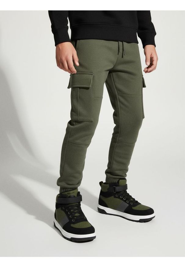 Sinsay - Spodnie dresowe cargo loose - zielony. Kolor: zielony. Materiał: dresówka